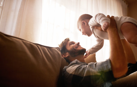 She lifts his spirits. an affectionate father bonding with his baby girl at home.