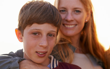 She treasures her only son. Portrait of a happy mother and son standing outside together.の写真素材