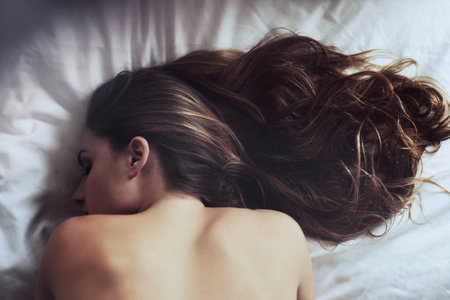 a beautiful young woman sleeping on her bed.の写真素材