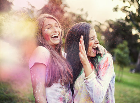 Color them crazy. happy friends having fun with powder paint.の写真素材