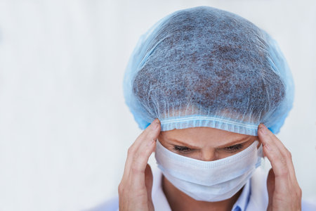 Staying focused for the big operation ahead. a female surgeon wearing a surgical cap and mask.の写真素材