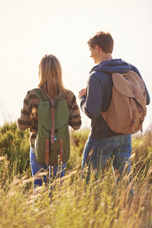 Taking in the view. Rear view shot of a happy couple out on a hike together.