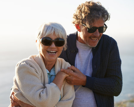Living, loving and laughing. Cropped view of a senior couple standing on a hillside together.