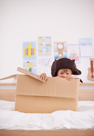 The piratical power of imagination. Portrait of a little pirate hiding in a cardboard box.の写真素材