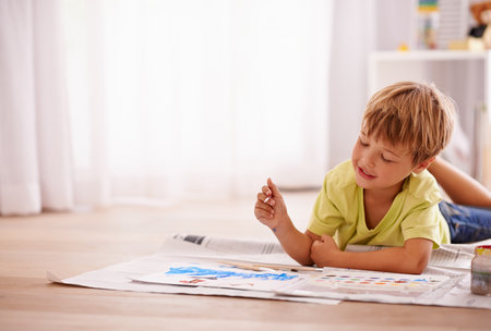 Unleash your childs creativity. a cute little boy painting a picture at home.の素材 [FY310191737785]