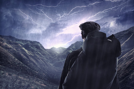 The majestic side of nature. a hiker watching a thunderstorm over a mountain.