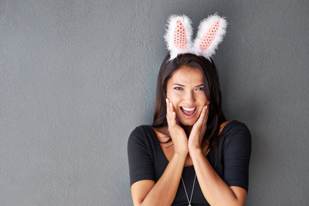 Playing it coy to lure him in. Portrait of a gorgeous brunette wearing bunny ears.の写真素材