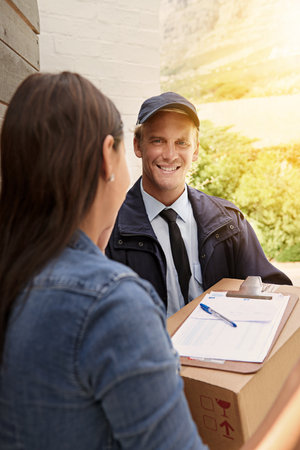 The friendly delivery man. a young man making a delivery to a woman at her home.