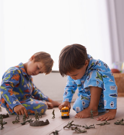 Imagination is their favourite toy. two little boys playing with their toys on the floor.の写真素材