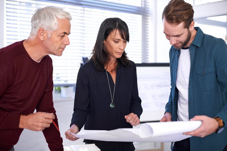These are my ideas. a group of architects discussing building plans in the office.