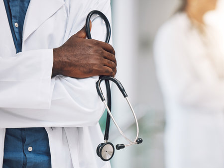 Healthcare, stethoscope in hand and African doctor in hospital. Black man or medical worker, leader in medicine and innovation in treatment. Confident, professional and expert patient care in Africa.の写真素材
