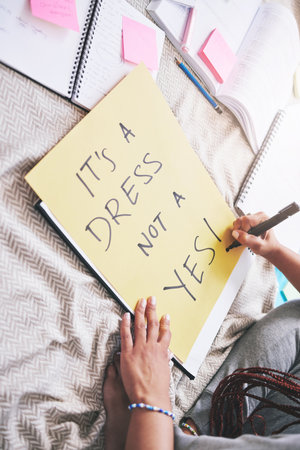 Woman activism, writing and sexual assault protest message for bold and angry statement poster. Girl sharing opinion and thought about rape problem with frustrated, protesting words on paper.の写真素材