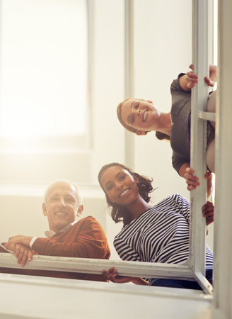 Looking down from the top of the corporate ladder. Portrait of a diverse group of smiling coworkers...