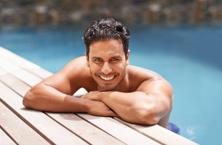 Portrait of a handsome young man sitting in a pool.の写真素材