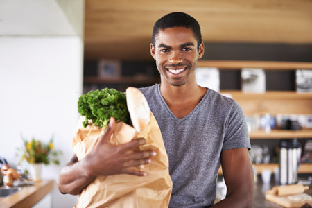 an African man holding the groceries heamp039s going to use to prepare supper.の写真素材