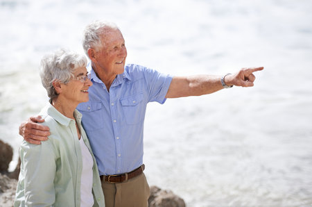 Enjoying the beauty of nature together. an elderly couple on the beach.の写真素材