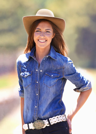 Ready to saddle up. Cropped image of a young cowgirl outside in the sun.の写真素材
