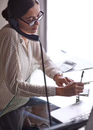 Multi-tasking like a champ. a beautiful young businesswoman working at her desk.