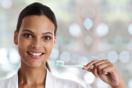 Dental hygiene is vital. Portrait of a smiling woman holding a toothbrush.の写真素材