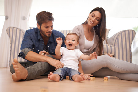 Meet the proud parents. a young married couple sitting at home with their baby.
