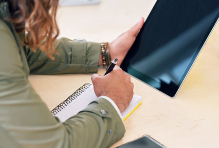 Hands of businessman with digital tablet and notebook for planning company project, report and...