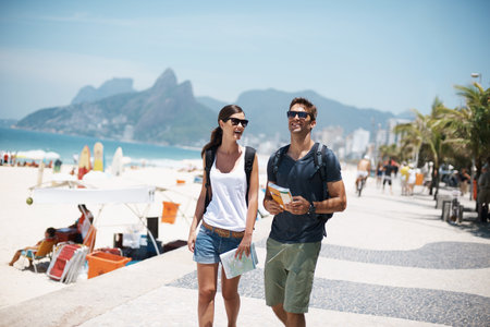 Strolling along through paradise. a young couple walking beside the beach.の写真素材