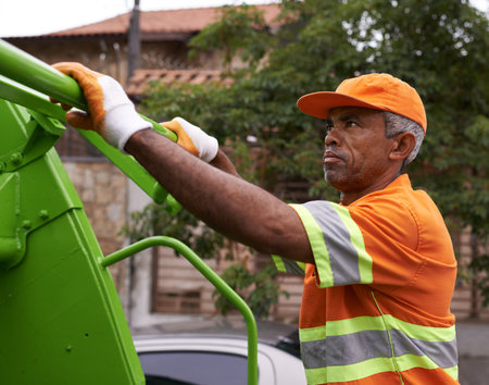 Hes keeping our streets clean. a male worker on garbage day.の写真素材