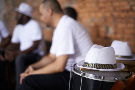 Feel the rhythm of the carnival. a hat on a drum with band members sitting in the background.の写真素材