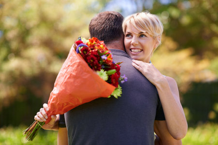I love my flowers just like you. a mature couple embracing after receiving a bouquet lf flowers.の写真素材