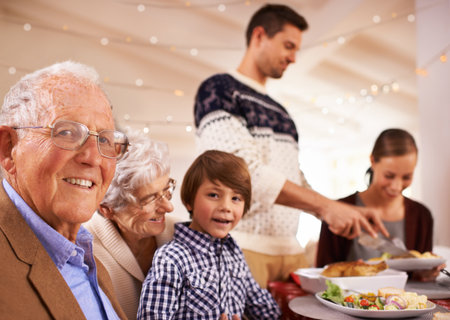 Having a family lunch on Christmas day. A happy family sitting around the dinner table on Christmas day.の写真素材