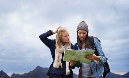 I think we might be lost...two female backpackers holding a map and looking confused.の写真素材