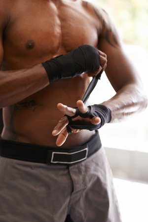 Pre fight focus. Closeup shot of a boxer wrapping his hands before a workout.の写真素材