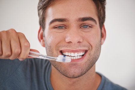 Keeping his teeth sparkly white. a man brushing his teeth.の写真素材