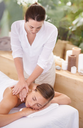 Spa Day. A beautiful young woman getting a massage by a spa therapist.の写真素材