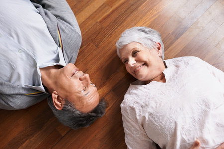 Still sweethearts after all these years. a happy-looking elderly couple lying down and smiling.の写真素材