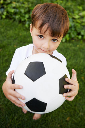 Backyard soccer. A sweet little boy with a soccer ball in the backyard.の写真素材