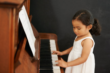 Virtuoso in the making. a little girl playing the piano.の写真素材