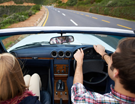 When the open road calls...Rear view of a young couple driving in a car.の写真素材