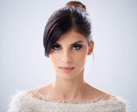 Classic casual beauty. A beautiful young woman in a furry jersey smiling at the camera.の写真素材