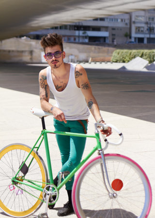 Retro cycle style. A handsome young man riding his bicycle outdoors.の写真素材