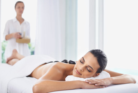 It doesnt get anymore relaxing...a beautiful young woman relaxing during spa treatment.の写真素材