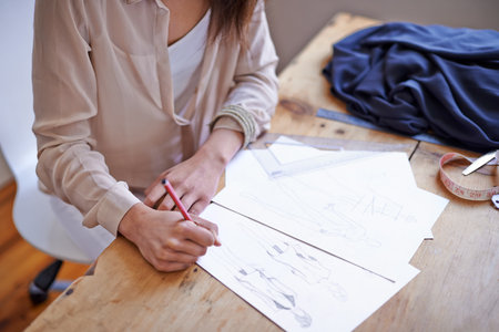 Coming up with new style trends. A fashion designer drawing sketches in her office.
