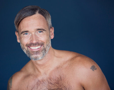 Hes got rugged good looks. Portrait of mature man posing against a dark background.の写真素材