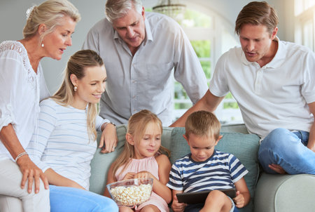 Streaming, media and family watch tablet movies entertainment on internet mobile app together in living room. Happy family people love watching online reunion film series on technology in home loungeの写真素材