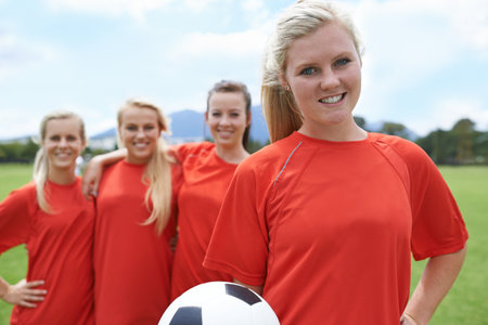 Theyre proud of their achievements. Portrait of a young female soccer player and her teammates.の写真素材