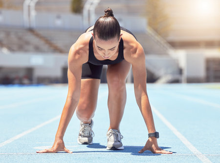 Motivation, energy and runner start training at outdoor track, ready to practice go. Health, power and fitness goal by professional woman athlete with strong mindset prepare for speed, cardio sprintの写真素材