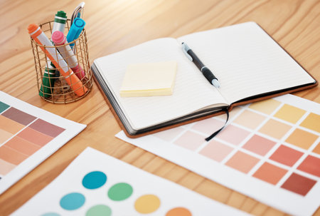 Notebook, color swatch and designer paper documents for design, marketing and advertising creative strategy on office desk. Zoom on book, infographic data chart for project or paint catalogの写真素材