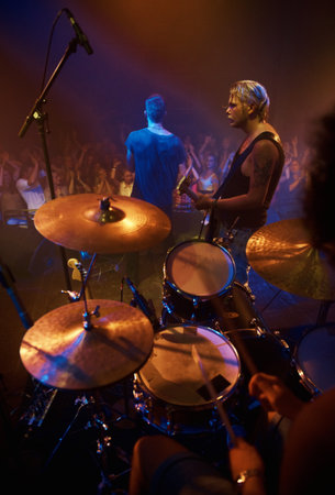 Performing the gig of a lifetime. Rear view of a band performing on stage at a music festival.の写真素材