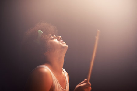 Smacking the skins hard. A young drummer rocking out on stage.の写真素材