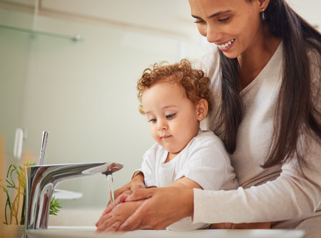 Mother, boy or washing hands help in water in covid bacteria cleaning, home morning wellness or learning hygiene. Child, son or kid by house bathroom sink in healthcare security or safety with parentの写真素材